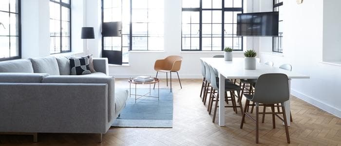  A living room and dining room area with a lot of space and big windows. 