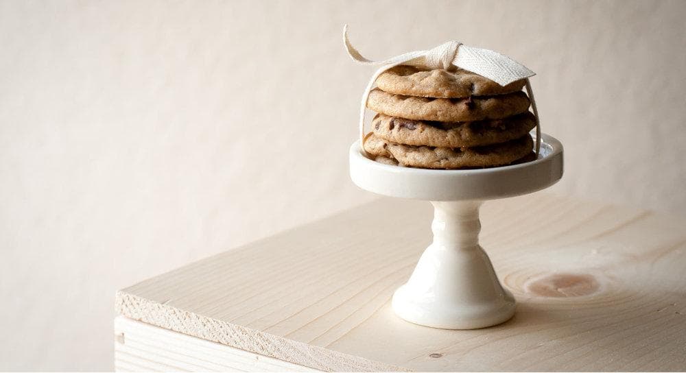  A beautiful display of a stack of cookies on a platter, tied with a bow. 